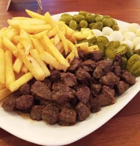 a plate of food with french fries and pickles at Acacia hotel in Laguna