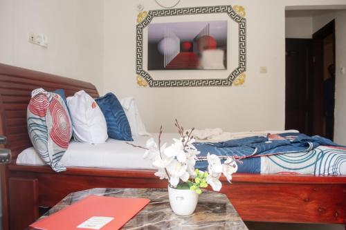 a bedroom with a bed with a table and a mirror at Résidence Le Sommet Douala in Douala