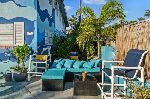 a patio with chairs and a blue couch and chairs at Blue Bell Apartment Hotel in Fort Lauderdale