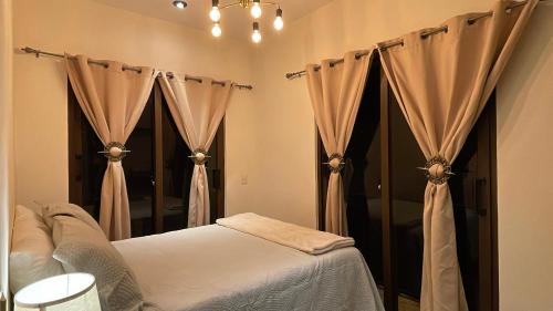 a bedroom with a bed with curtains in it at Casa grande de lujo cerca Antigua Guatemala in Antigua Guatemala