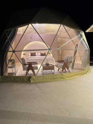 Al RakaにあるSunset domes private campのベッドとテーブルが備わったテント