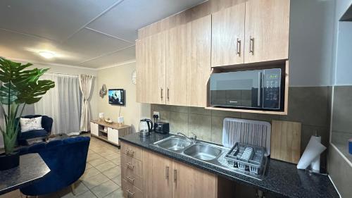 a kitchen with a sink and a microwave at Nyasa Apartment in Johannesburg