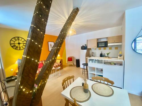 une cuisine et un salon avec une table et des chaises dans l'établissement Bel Appartement Chaleureux 306 - Le Garbet - Résidence Grand Hôtel, à Aulus-les-Bains