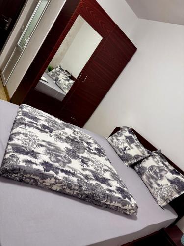 a bed with a pillow and a mirror in a room at Home Efrem in Bucharest