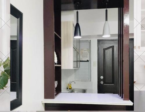 a kitchen with a black door and a sink at Estien’s Cozy Condotel to Stay in Imus