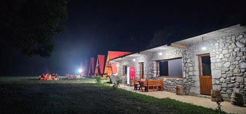 a group of buildings at night with lights at Ekoo katun Jezerca in Vusanje