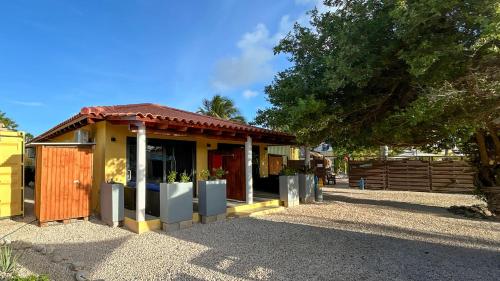 a small building with a fence and a tree at Sonrisa Boutique Hotel - Adults Only in Kralendijk