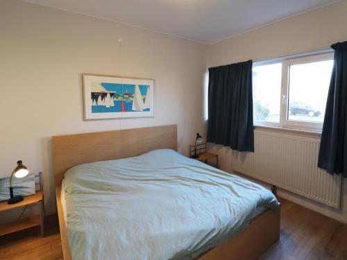 a bedroom with a bed and a window at Apartment in Heeg with Heegermeer Views in Heeg