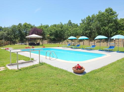 a large swimming pool with umbrellas and chairs at Agriturismo la Coccinella in Poggioni