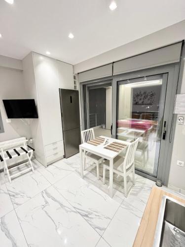 a living room with a table and chairs and a tv at BlueLine apartment 2 in Loutraki