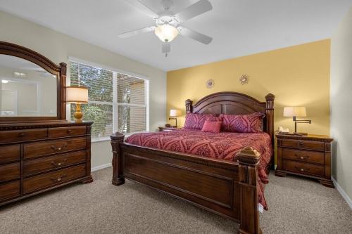 a bedroom with a bed and a dresser and a mirror at Lazy River Resort Townhome in Davenport