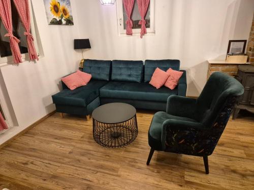 a living room with a green couch and a chair at Vila Ema-kuća za odmor in Ludbreg