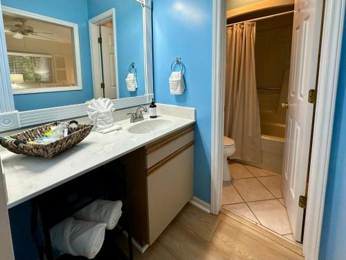 une salle de bain avec un lavabo, des toilettes et un miroir dans l'établissement Golf/ Beach Penthouse Condo, à Sunset Beach