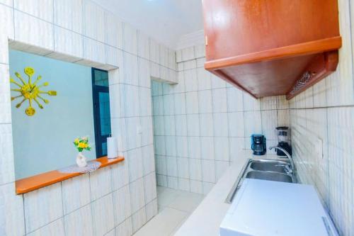 a small kitchen with a sink and a mirror at Résidence Le Prestige in Yaoundé