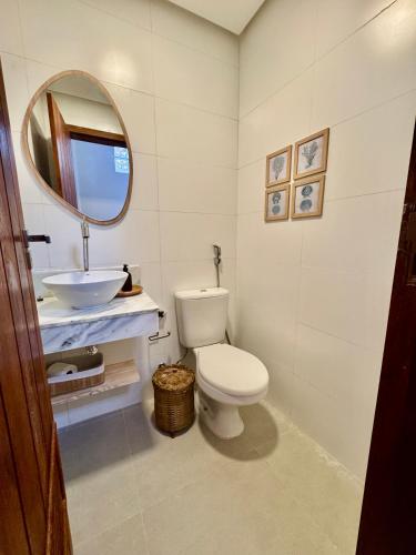 a bathroom with a white toilet and a sink at Casa João de Barro in Itacaré