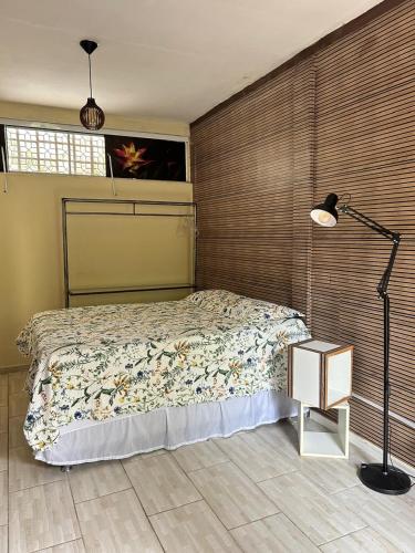 a bedroom with a bed and a lamp in it at Studio Dunas Porto Lagoa in Florianópolis