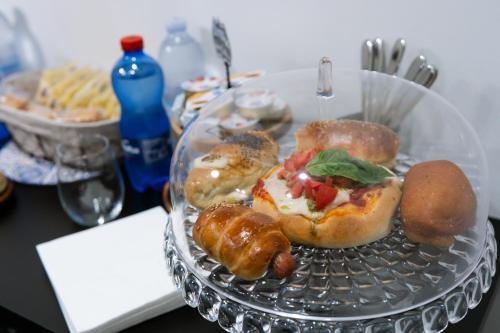 a glass plate with donuts and pastries on a table at Butera 505-Luxury Suites in Bagheria