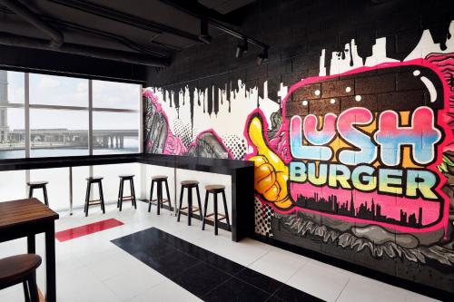 a bar with stools and a wall covered in graffiti at JW Marriott Marquis Hotel Dubai in Dubai