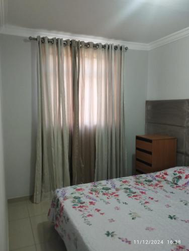 a bedroom with a bed and a window with curtains at Mi casa su casa 4 in Londrina