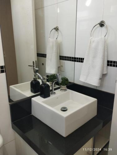 a bathroom with a white sink and a mirror at Mi casa su casa 4 in Londrina