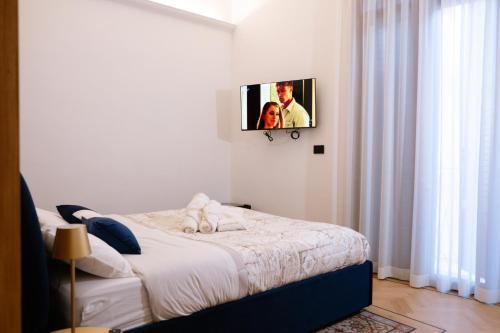 a bedroom with a bed with a tv on the wall at Butera 505-Luxury Suites in Bagheria