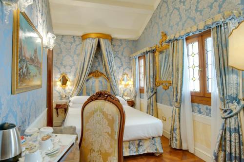 a bedroom with blue walls and a bed with a chair at Canal Grande in Venice