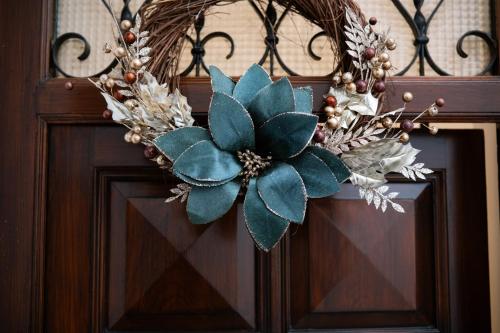 a wreath with a green flower on a door at Butera 505-Luxury Suites in Bagheria