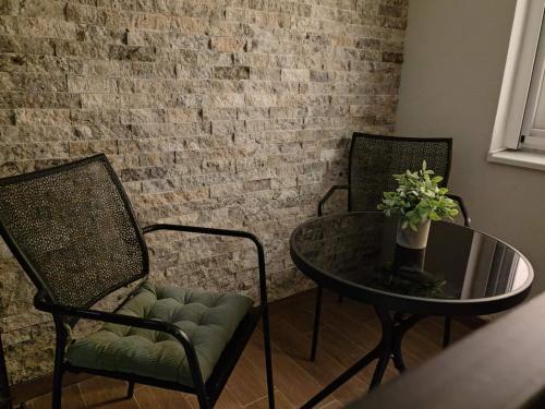 a table and two chairs and a table with a glass table and a tableablish at Surčin Central Stay in Surčin