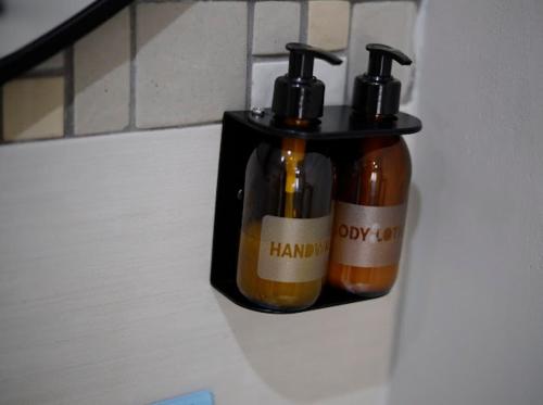 two bottles of soap in a holder on a wall at Summer PALACE Guesthouse in Bloemfontein