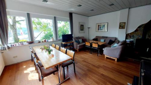 a living room with a table and chairs and a couch at Villa Gast - Salmagundi, für Gruppen bis 16 Gäste in Kamp-Bornhofen