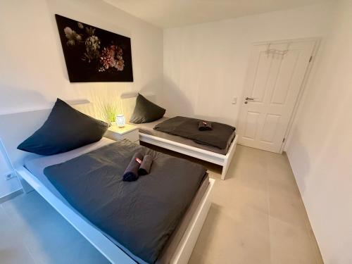 zwei Einzelbetten in einem Zimmer mit einer Tür in der Unterkunft Apartment WH7 in Frechen