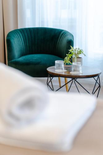 a living room with a green couch and a coffee table at Hama Boutique Stays in Budapest