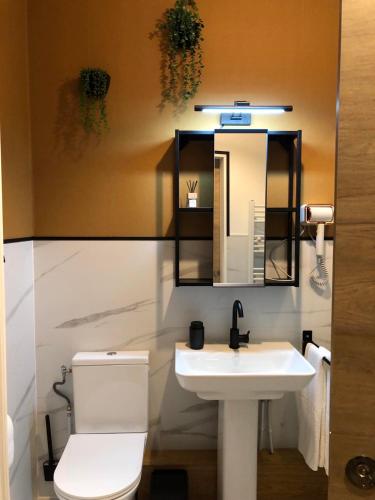 une salle de bain avec toilettes, lavabo et miroir dans l'établissement L'URBANA Rooms, à Noyelles-Godault