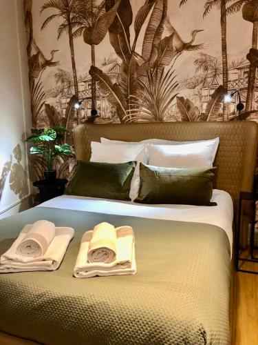 une chambre avec un lit avec deux serviettes dessus dans l'établissement L'URBANA Rooms, à Noyelles-Godault