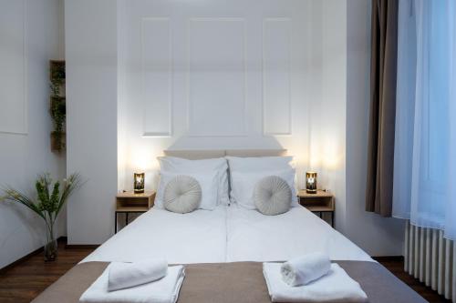 a bedroom with a white bed with two night stands at Hama Boutique Stays in Budapest