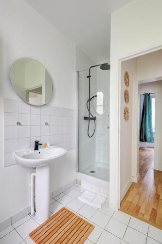 une salle de bain blanche avec un lavabo et une douche dans l'établissement Le Bellanger - Duplex tout équipé proche Paris, à Levallois-Perret