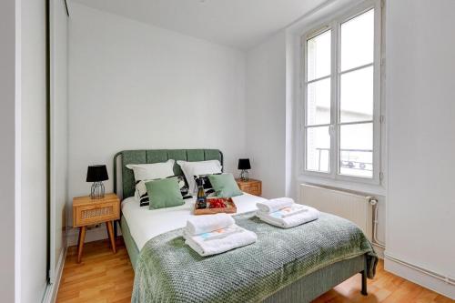 une chambre avec un lit avec deux oreillers dessus dans l'établissement Le Bellanger - Duplex tout équipé proche Paris, à Levallois-Perret
