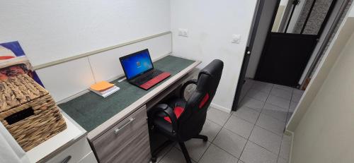 a room with a desk with a laptop and a chair at T3 spacieux lumineux jardin et proche du tram in Pont-de-la-Maye