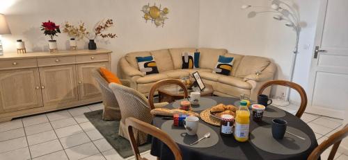 a living room with a table and chairs and a couch at T3 spacieux lumineux jardin et proche du tram in Pont-de-la-Maye