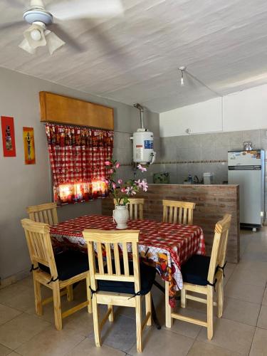 a dining room with a table and chairs and a kitchen at La Mericia in Villa Carlos Paz