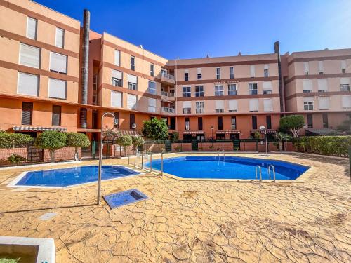 a swimming pool in front of a building at Mariposa in El Médano