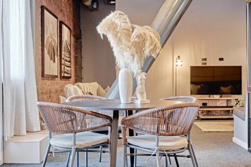 a dining room with a table with chairs and a vase at The Loft on Cuba in Wellington
