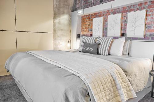 a bedroom with a large bed with a brick wall at The Loft on Cuba in Wellington