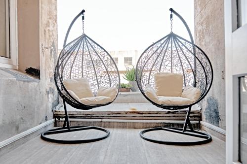 two hanging chairs in a room with a window at The Loft on Cuba in Wellington