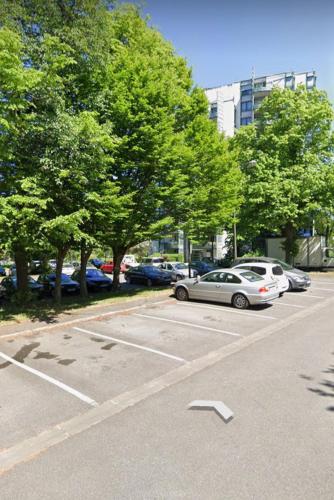 a parking lot with parked cars and trees at Entre Ville & Nature-Sejour idéal a Massy in Massy