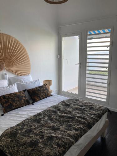 a bedroom with a large bed with a large window at Ans'O - Les Anses d'Arlet in Les Anses-dʼArlets