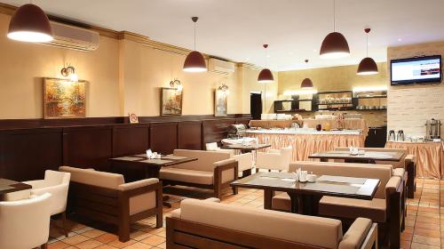 un restaurante con mesas y sillas y un bar en Kalasi Hotel, en Tiflis