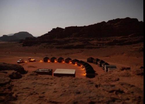 a group of tents in the desert at night at Wadi Rum Travel camp in Wadi Rum