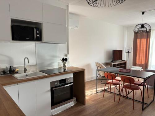une cuisine et une salle à manger avec une table et des chaises dans l'établissement Appartement familial avec parking privatif, à Carcassonne