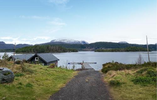 a path next to a lake with mountains in the background at Beautiful Home In Skodje in Vatne